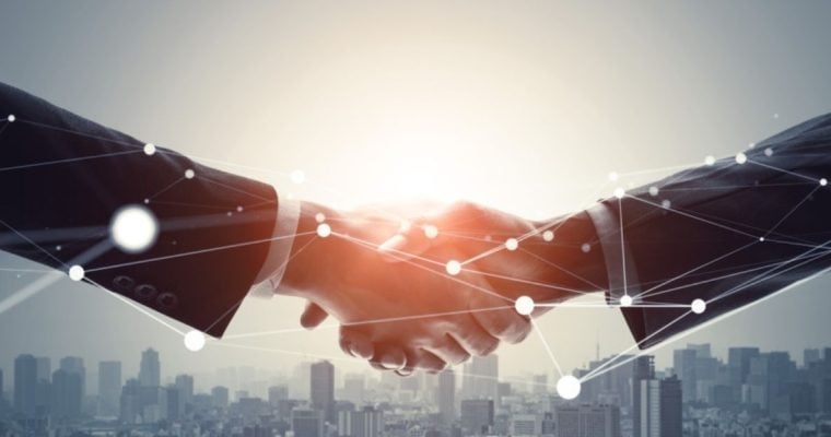 Two Businessmen Shake Hands Above City Skyline with Geolocation Dots Overlay