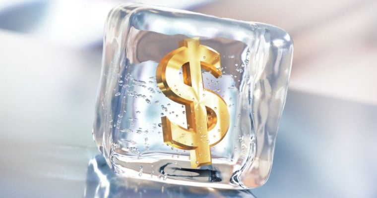 Block of Ice with Golden Dollar Symbol inside Represents Frozen Money