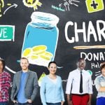 Blackboard with Sketch Images of Charity Donations and People Standing in Front