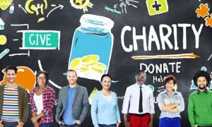 Blackboard with Sketch Images of Charity Donations and People Standing in Front