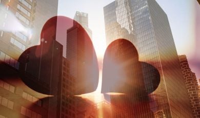 Double Exposure Image of Two Red Hearts On Cityscape Background
