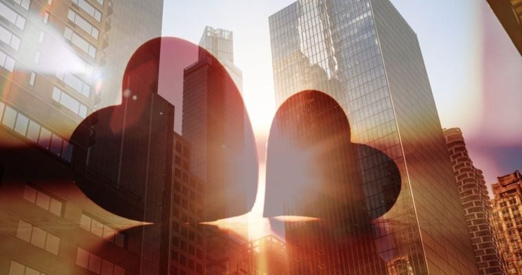 Double Exposure Image of Two Red Hearts On Cityscape Background