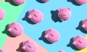 One Piggy Bank Faces Viewer While Others Face Left On Colored Flat Background
