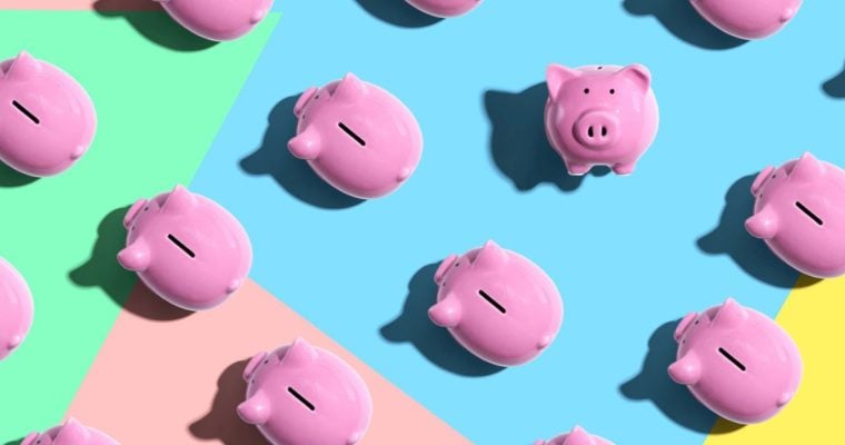 One Piggy Bank Faces Viewer While Others Face Left On Colored Flat Background