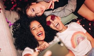 Three Gen Z Women Use Cell Phone to Take Selfie