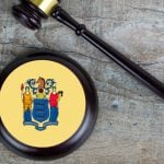 Judge's Gavel and Mallet with NJ State Flag Lay on Wood Background