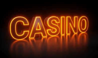 Bright Orange Neon Sign on Black Background Reads "Casino"