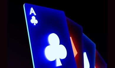 Blue Neon-Lit Ace of Clubs Playing Card Sits In Front of 3 Others