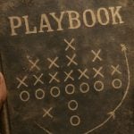 Man's Hands Hold Old Brown Playbook with Game Moves On Cover