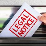 White Envelope with Red Letters Read Legal Notice Pulled Out of Mailbox
