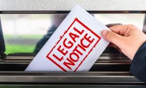 White Envelope with Red Letters Read Legal Notice Pulled Out of Mailbox