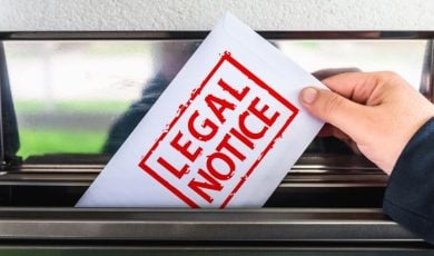 White Envelope with Red Letters Read Legal Notice Pulled Out of Mailbox