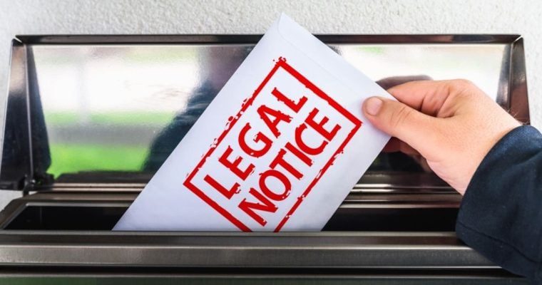 White Envelope with Red Letters Read Legal Notice Pulled Out of Mailbox