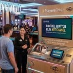 Casino Guest Speaks with Hard Rock Employee on Responsible Gambling Tools on Casino Floor