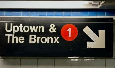 Subway Sign in NYC Reads Uptown & The Bronx with 1 in Red Circle