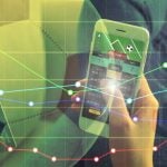 Man Holds Cell Phone With Sports Betting App and Finacial Line Graph Image Overlay