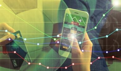 Man Holds Cell Phone With Sports Betting App and Finacial Line Graph Image Overlay