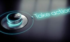 Neon Sign Reads Take Action! Next To Dial on Black Background