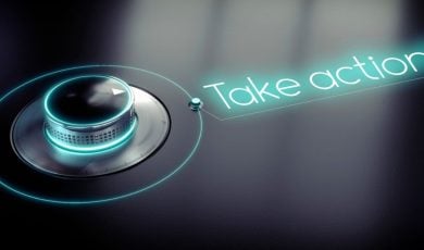 Neon Sign Reads Take Action! Next To Dial on Black Background