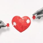 Black & White Hands Place Missing Red Pieces of Heart Puzzle