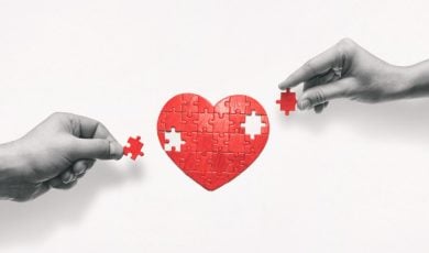 Black & White Hands Place Missing Red Pieces of Heart Puzzle