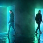 Bright Blue/Green Doors in Dark Room with Two People Going Opposite Directions