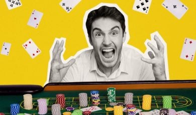 Man Sits In Front of Stacked Poker Chips with Excited Expression