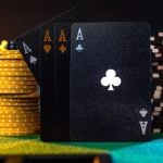 4 Aces Stand On Green Game Table Surrounded By Stacks of Poker Chips
