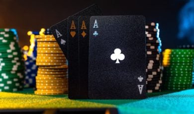 4 Aces Stand On Green Game Table Surrounded By Stacks of Poker Chips