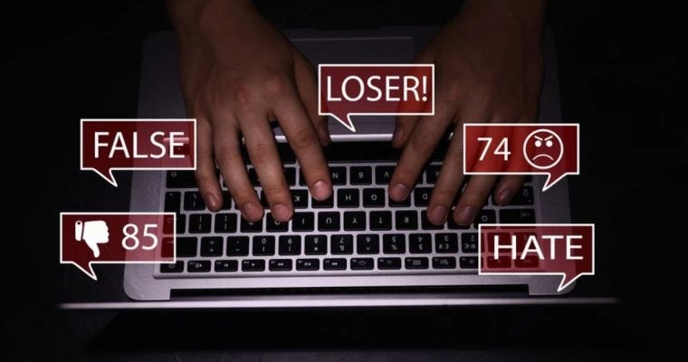 Red Speech Bubbles Display Abusive Language as Man Types on Laptop
