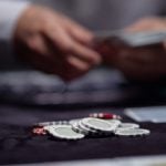 Concept of Poker Game, Live Dealer Dealing Cards with Poker Chips on Game Table