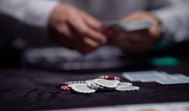 Concept of Poker Game, Live Dealer Dealing Cards with Poker Chips on Game Table
