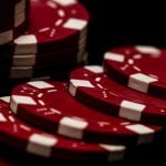 Red and White Poker Chips Stacked and Laying on Black Background