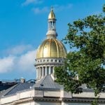 Blue Skies and Green Tree Top Surround Gold Dome at the Capitol Building in New Jersey