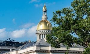 Blue Skies and Green Tree Top Surround Gold Dome at the Capitol Building in New Jersey
