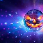 Scary Pumpkin Face Disco Ball Shines Orange and Blue Lights on Dark Wall