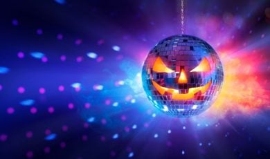Scary Pumpkin Face Disco Ball Shines Orange and Blue Lights on Dark Wall