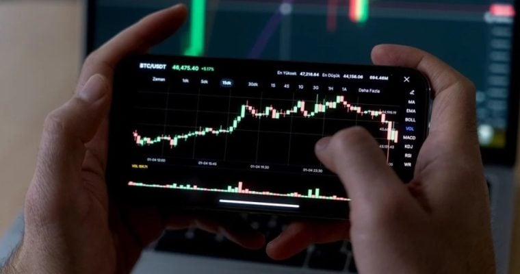 Man Uses Smartphone to Check Rising Financial Graph