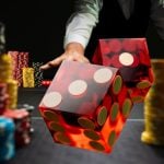 Two Red Dice Flying Over Game Table Lined With Colorful Money Chips