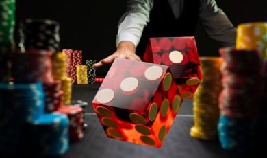 Two Red Dice Flying Over Game Table Lined With Colorful Money Chips