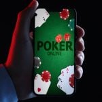 Online Poker App Displayed on Smartphone Held in Man's Hand