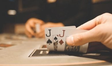 Man Has Spade and Diamonds of Jack Playing Cards For Poker Hand