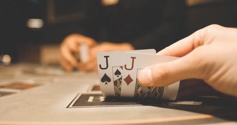 Man Has Spade and Diamonds of Jack Playing Cards For Poker Hand