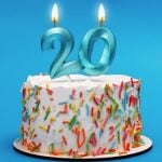 White Birthday Cake Has Blue 20 Candles Lit Up