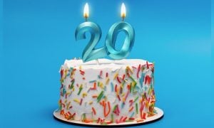 White Birthday Cake Has Blue 20 Candles Lit Up