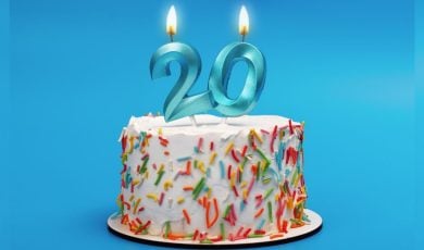 White Birthday Cake Has Blue 20 Candles Lit Up