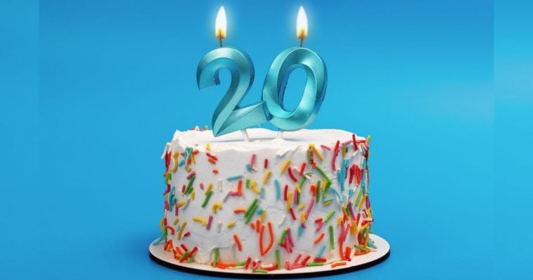 White Birthday Cake Has Blue 20 Candles Lit Up