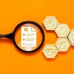 Magnifying Glass Sits Over Survey Document with White Checks on Wooden Blocks