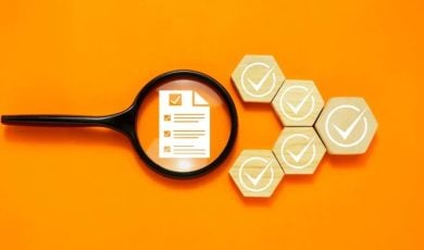 Magnifying Glass Sits Over Survey Document with White Checks on Wooden Blocks