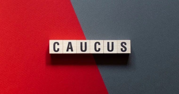 Red and Grey Split Background with Wooden Blocks Spelling Caucus